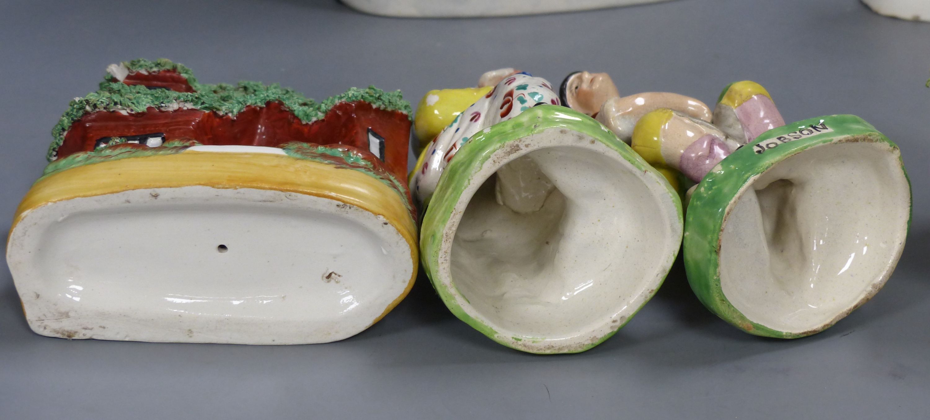 A pair of 19th century Staffordshire figures, 'Jobson' and 'Nellie', two castle flatback groups, a cottage pastille burner and a Gamekeeper and Poacher spill vase (6)